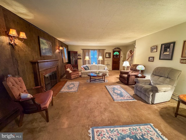 living room with wood walls, carpet floors, a textured ceiling, and a brick fireplace