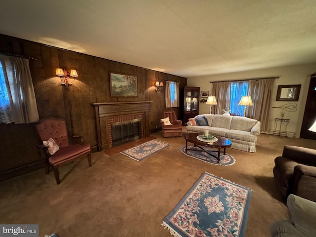 carpeted living room with wood walls and a fireplace