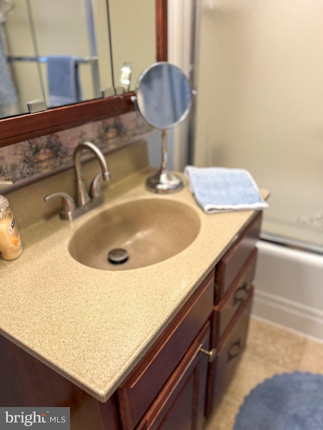 bathroom with vanity and enclosed tub / shower combo