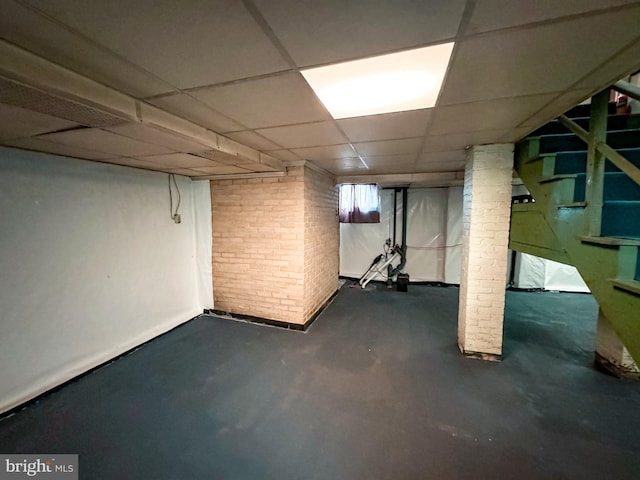 basement with a paneled ceiling