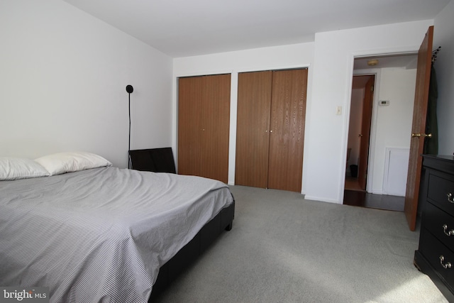 bedroom with carpet floors and two closets