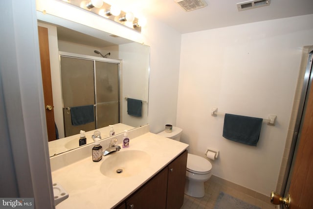 bathroom featuring vanity, a shower with door, tile patterned flooring, and toilet