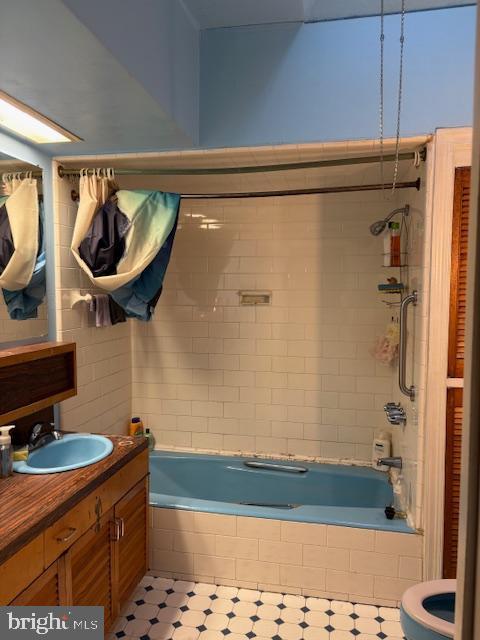 full bathroom featuring tile patterned flooring, vanity, toilet, and tiled shower / bath