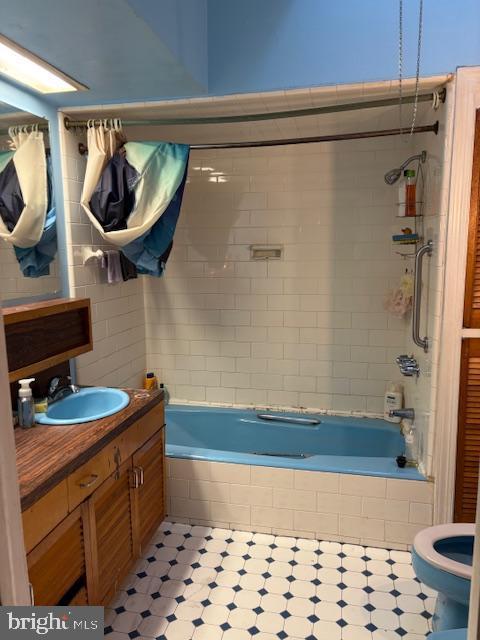 full bathroom with vanity, tiled shower / bath combo, and toilet