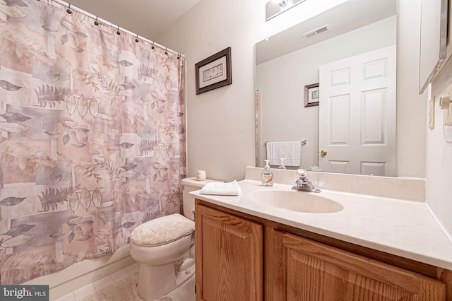 bathroom featuring tile patterned flooring, vanity, and toilet