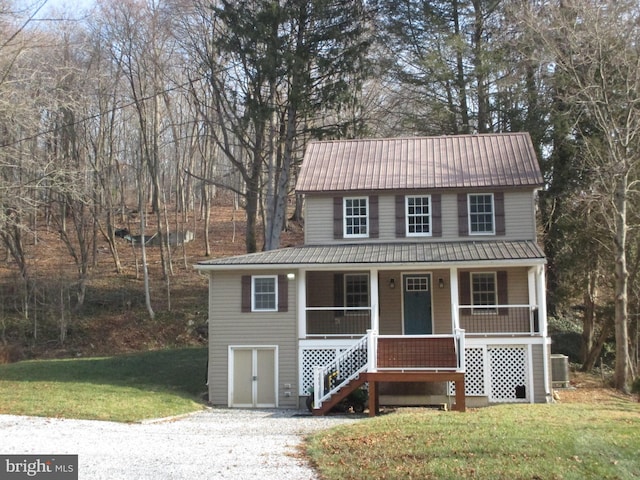 view of front of home with covered porch, central AC, and a front lawn