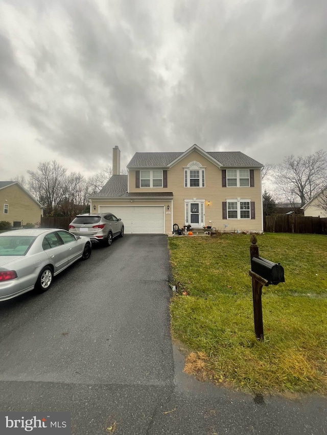 view of front of property with a front yard and a garage