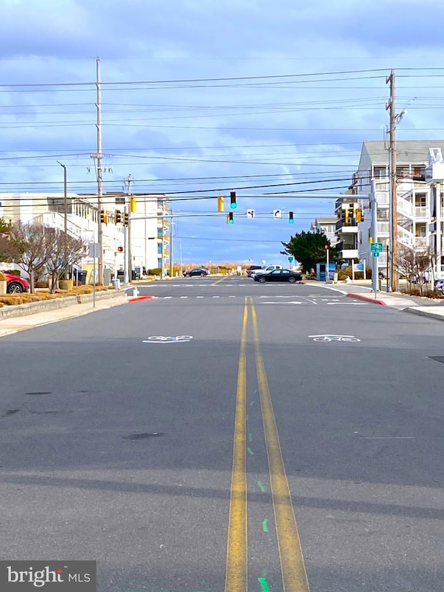 view of street featuring curbs, street lighting, traffic lights, and sidewalks