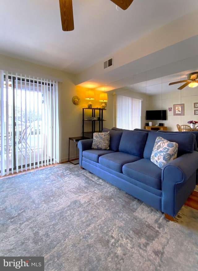 living room featuring visible vents and ceiling fan