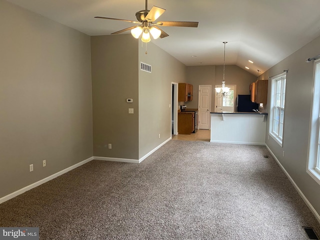 unfurnished living room featuring ceiling fan with notable chandelier, light colored carpet, and lofted ceiling