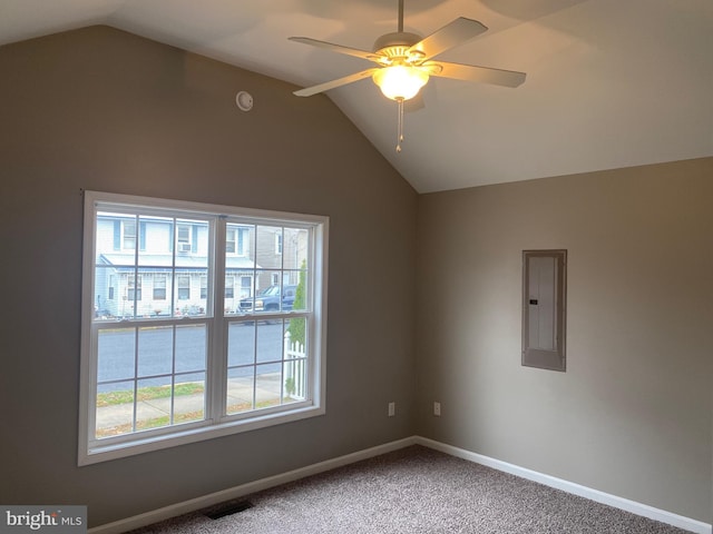 empty room featuring ceiling fan, a healthy amount of sunlight, lofted ceiling, and electric panel