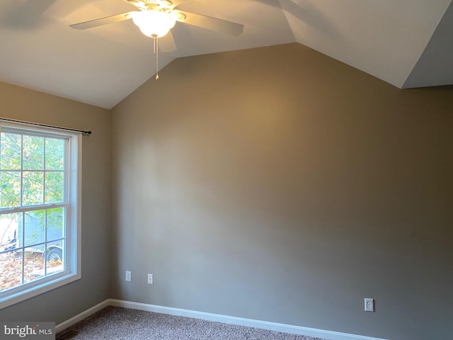 carpeted spare room featuring ceiling fan, a healthy amount of sunlight, and vaulted ceiling