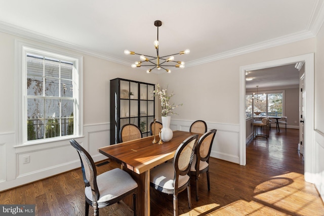 dining space with ornamental molding, dark wood-type flooring, and an inviting chandelier