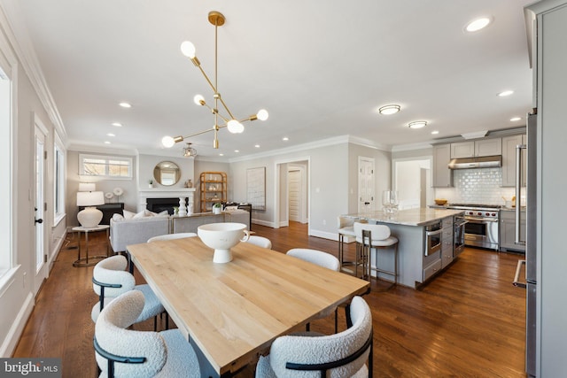 dining room with a notable chandelier, crown molding, and dark wood-type flooring