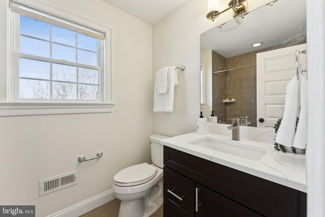 bathroom with tile patterned flooring, vanity, toilet, and tiled shower