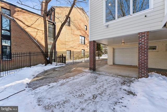 view of snow covered exterior with a garage