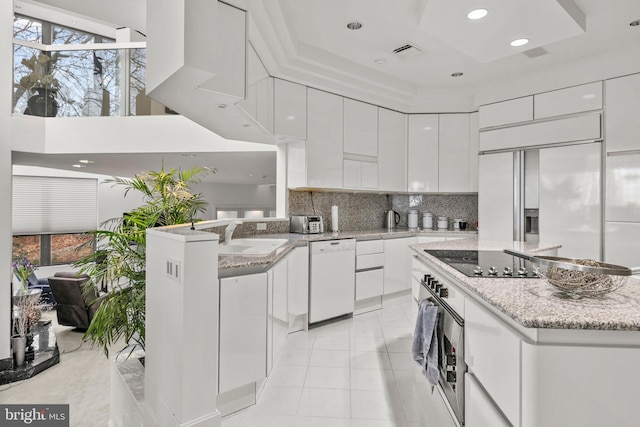 kitchen with white cabinets, black electric stovetop, white dishwasher, and sink