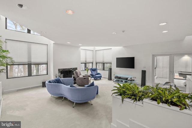 carpeted living room featuring lofted ceiling and a fireplace