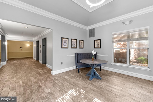 living area with light hardwood / wood-style flooring and ornamental molding