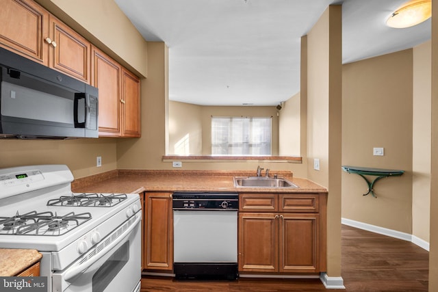 kitchen with dark hardwood / wood-style flooring, sink, and white appliances