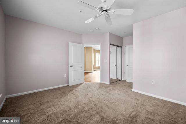 unfurnished bedroom featuring ceiling fan, a closet, and light colored carpet