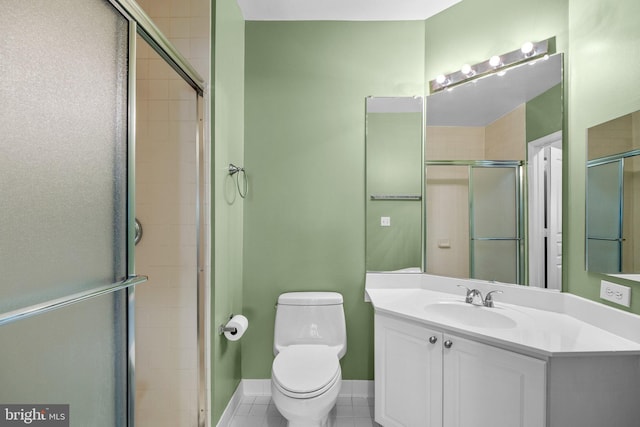 bathroom featuring tile patterned flooring, toilet, vanity, and walk in shower