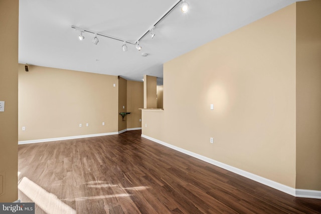 spare room with wood-type flooring and rail lighting