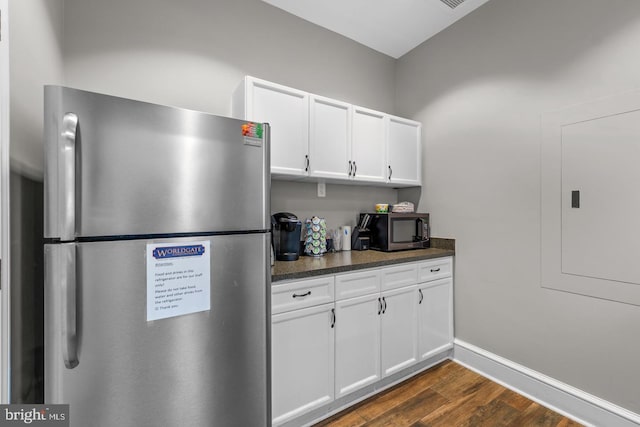 kitchen featuring white cabinetry, dark stone countertops, stainless steel fridge, and dark hardwood / wood-style flooring