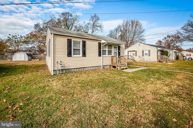 view of front of house featuring a storage unit and a front lawn