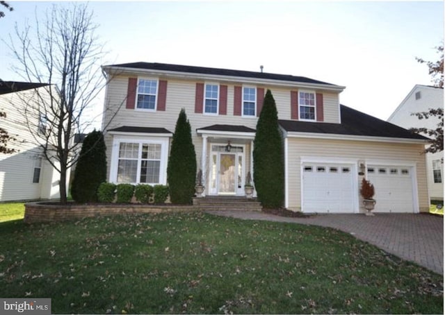 view of front of property with a garage and a front lawn