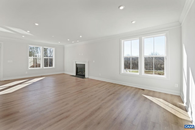 unfurnished living room with ornamental molding and light wood-type flooring