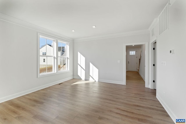 spare room featuring light hardwood / wood-style flooring and ornamental molding