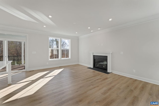 unfurnished living room featuring light wood-type flooring and ornamental molding