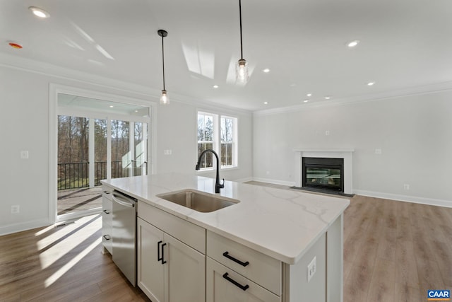 kitchen featuring sink, pendant lighting, light hardwood / wood-style flooring, dishwasher, and an island with sink