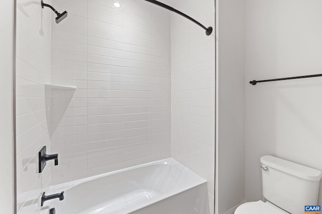 bathroom featuring toilet and tiled shower / bath