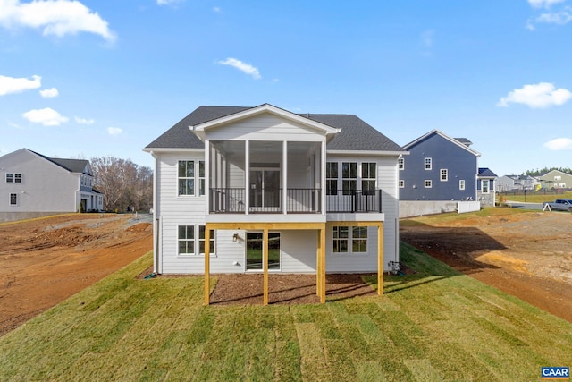 rear view of house with a sunroom and a yard