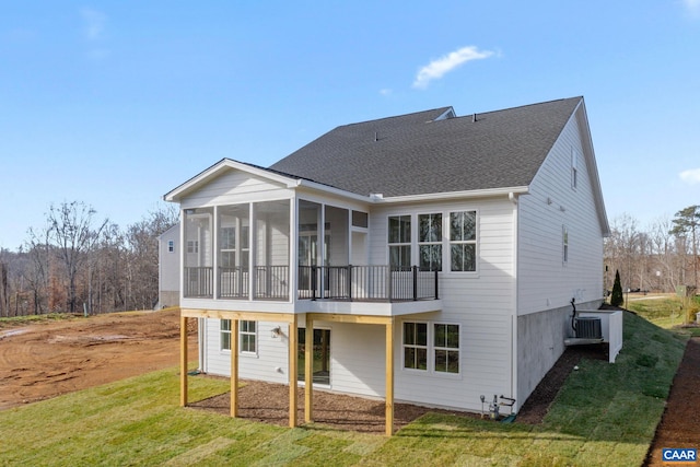 back of property with a sunroom and a yard