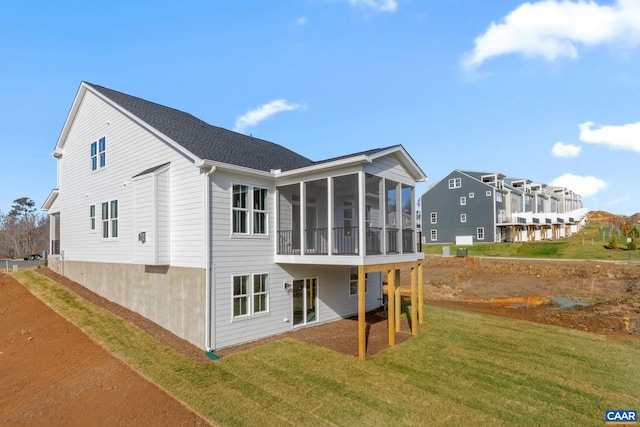 back of property with a sunroom and a yard