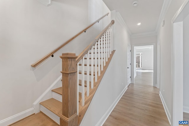 stairs with hardwood / wood-style floors and ornamental molding