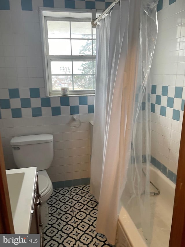 full bathroom featuring vanity, tile patterned floors, shower / bath combination with curtain, toilet, and tile walls