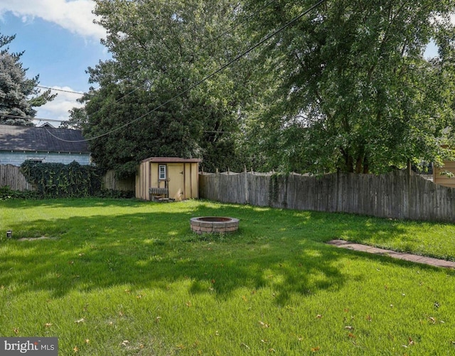 view of yard with a storage unit and an outdoor fire pit