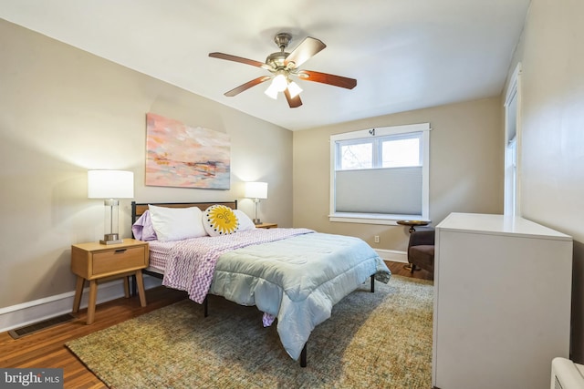 bedroom with dark hardwood / wood-style flooring and ceiling fan