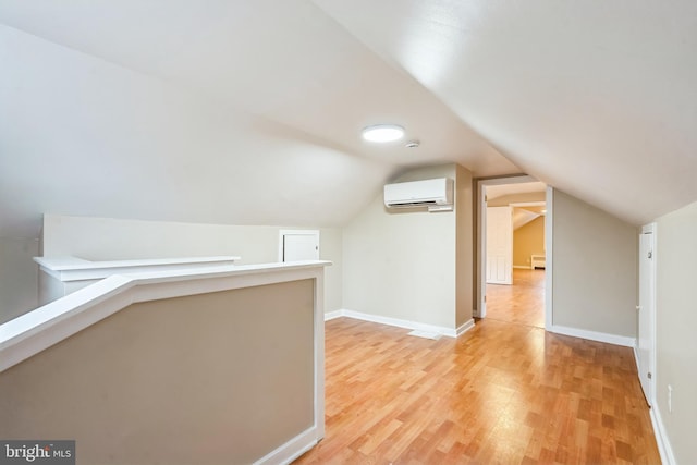 additional living space featuring light hardwood / wood-style floors, lofted ceiling, a baseboard radiator, and a wall mounted AC