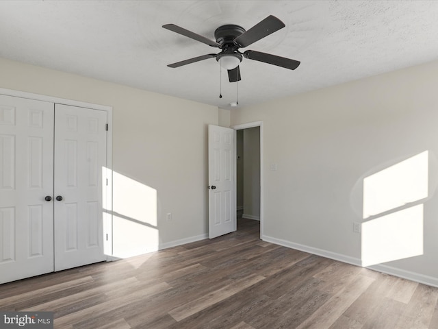 unfurnished bedroom featuring ceiling fan, a closet, and hardwood / wood-style floors