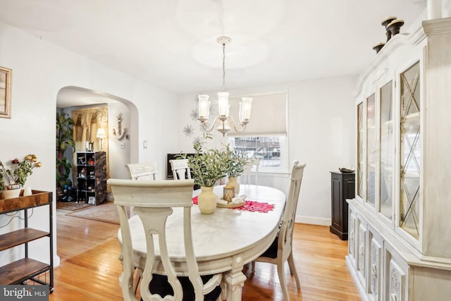 dining area with a chandelier and light hardwood / wood-style floors