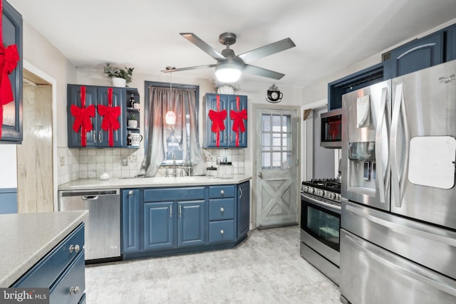 kitchen with blue cabinets, hanging light fixtures, decorative backsplash, ceiling fan, and stainless steel appliances