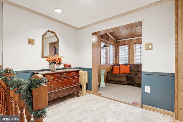 living area with wooden ceiling, wooden walls, light colored carpet, and crown molding