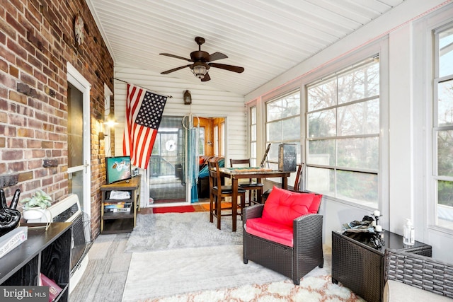 sunroom with ceiling fan, wooden ceiling, and vaulted ceiling