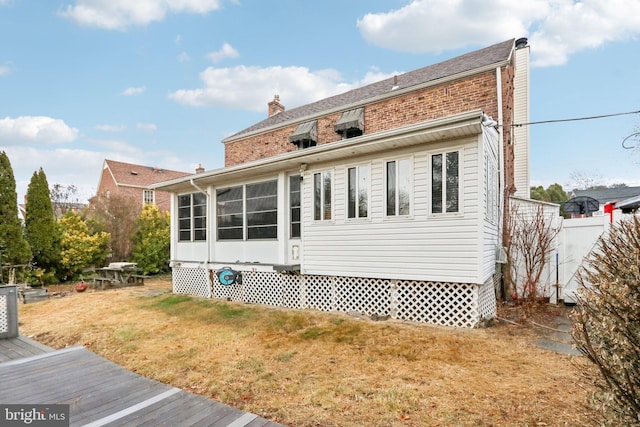 rear view of house featuring a yard