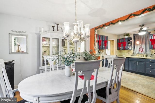 dining area featuring ceiling fan with notable chandelier and light wood-type flooring